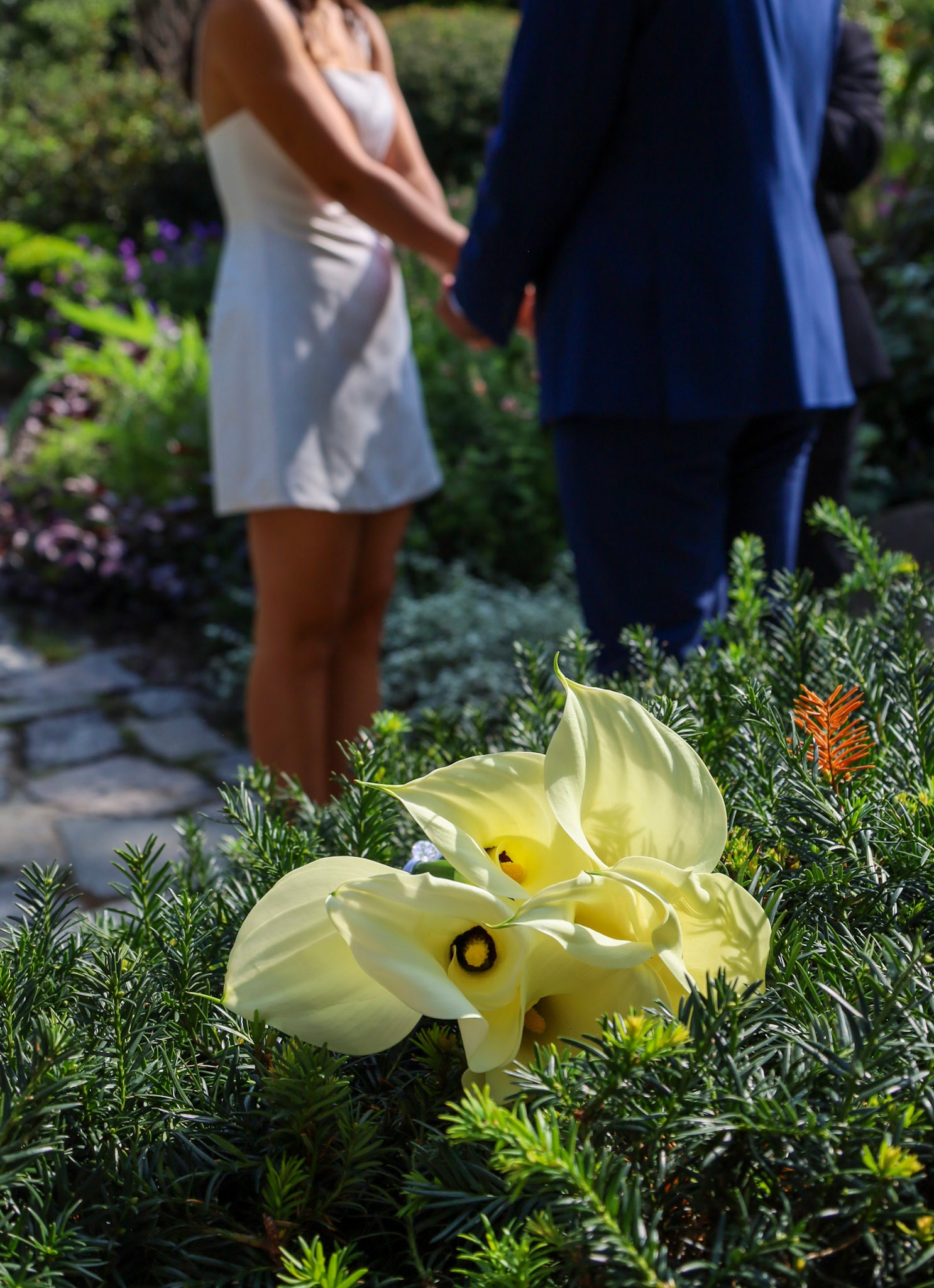BeniCelo wedding - yellow calla lily bouquet detail with couple in background